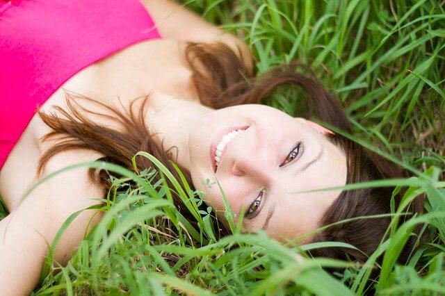 Girl with Flawless skin lied on the grass