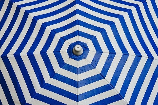 BEAUTIFUL WHITE AND BLUE STRIPED UMBRELLA AS SHIELD