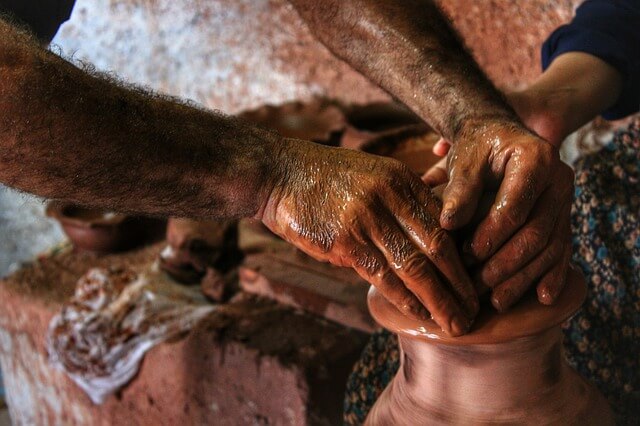 Potter giving shape to Mud dough to make a Clay pot